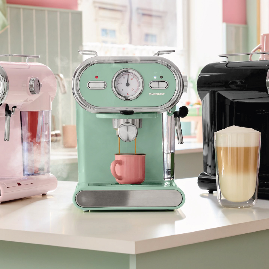 Три еспресо машини Silvercrest в розово, ментово зелено и черно на кухненски плот.