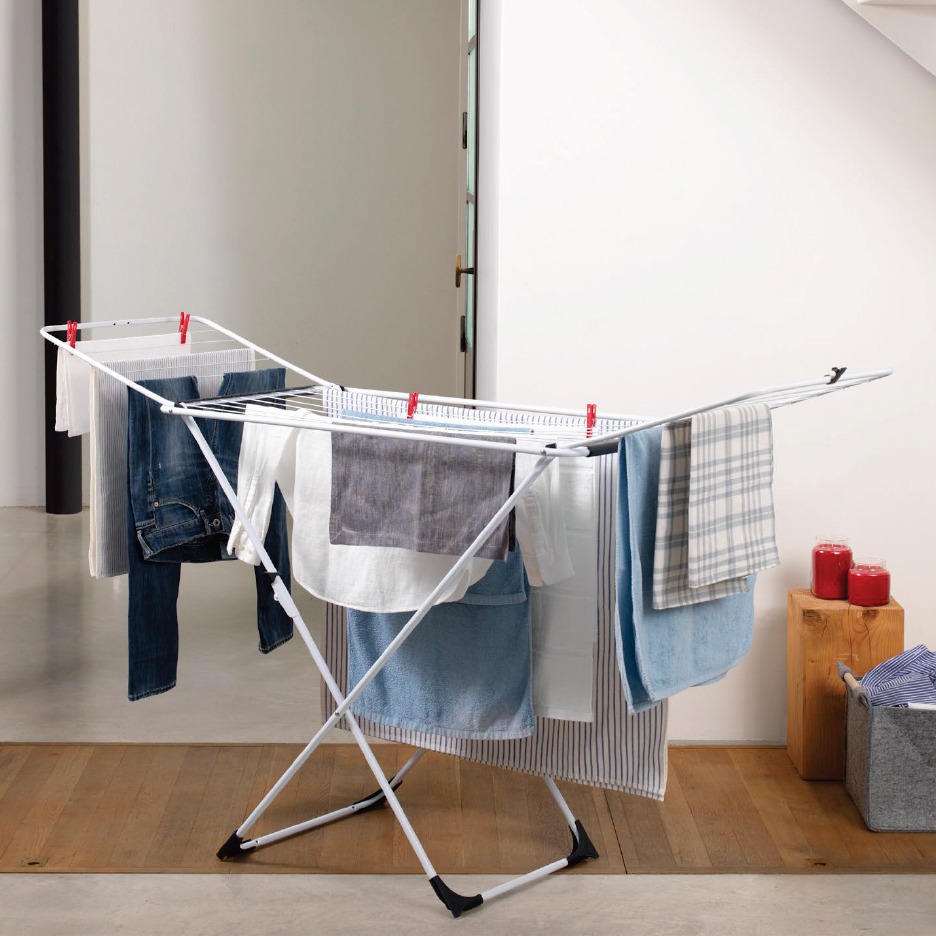 Сушилник за дрехи с пране в стая с дървен под