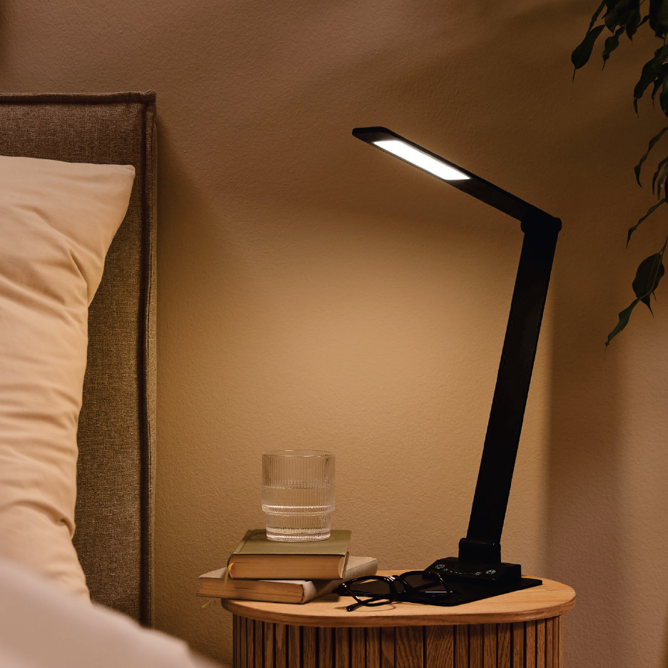 Нощна лампа с LED осветление, чаша вода и книги на нощно шкафче до легло.