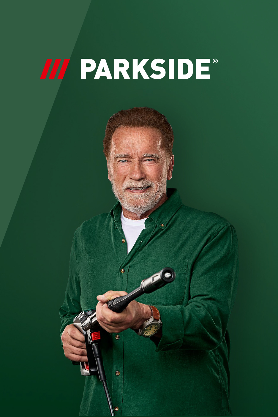 Арнолд Шварценегер държи водоструйка Parkside на зелен фон.