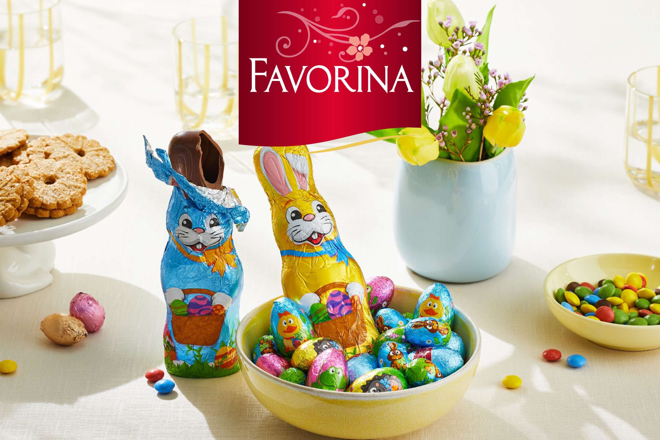 Великденски шоколадови зайци и яйца, бисквити и бонбони на маса.