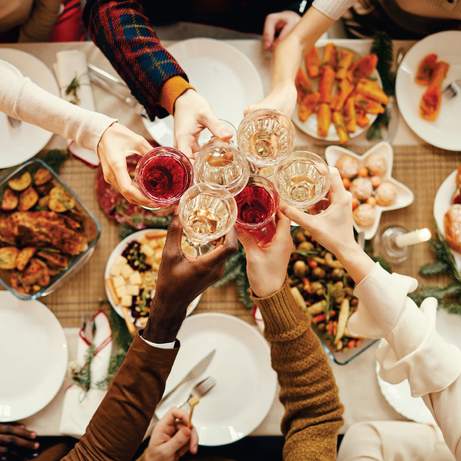 Празнична трапеза с наздравица с вино и различни ястия.