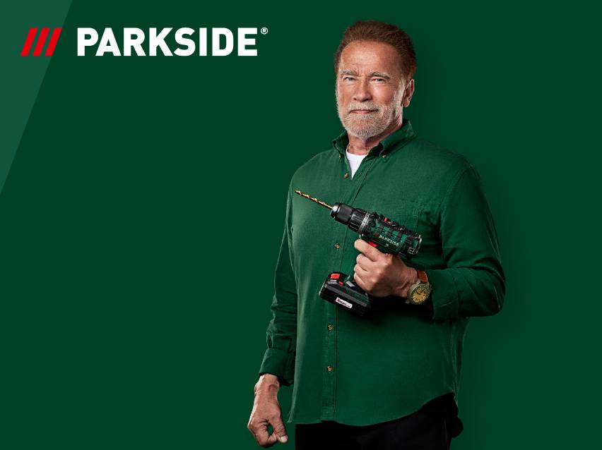 Мъж държи акумулаторна бормашина на зелен фон с лого на марка.