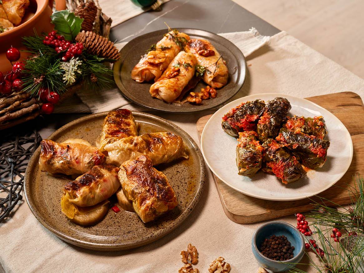 Пълнени зелеви и лозови сарми, поднесени на празнична маса.