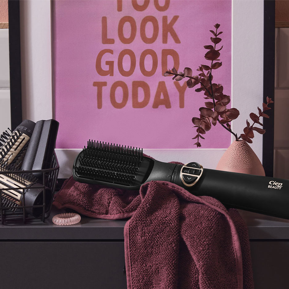 Четка за изправяне на коса Cien Beauty върху кърпа, с аксесоари за коса и плакат.