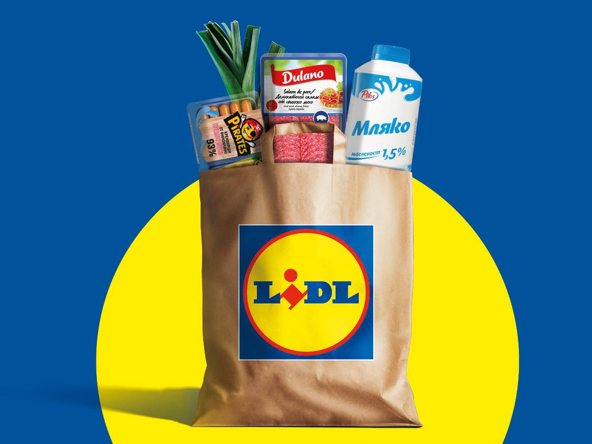 Кафява пазарска чанта на Lidl, пълна с хранителни стоки като мляко, колбаси и праз.