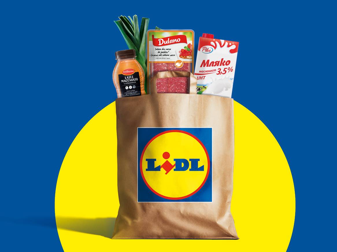 Кафява хартиена торба с лого на Lidl, пълна с мляко, салам, кафе напитка и праз.