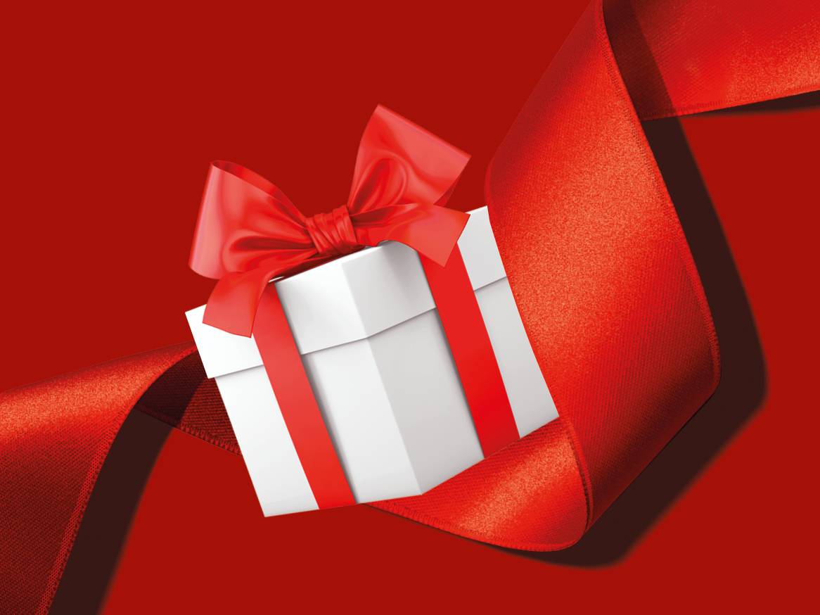 Бяла подаръчна кутия с червена панделка, увита в червена сатенена лента на червен фон.