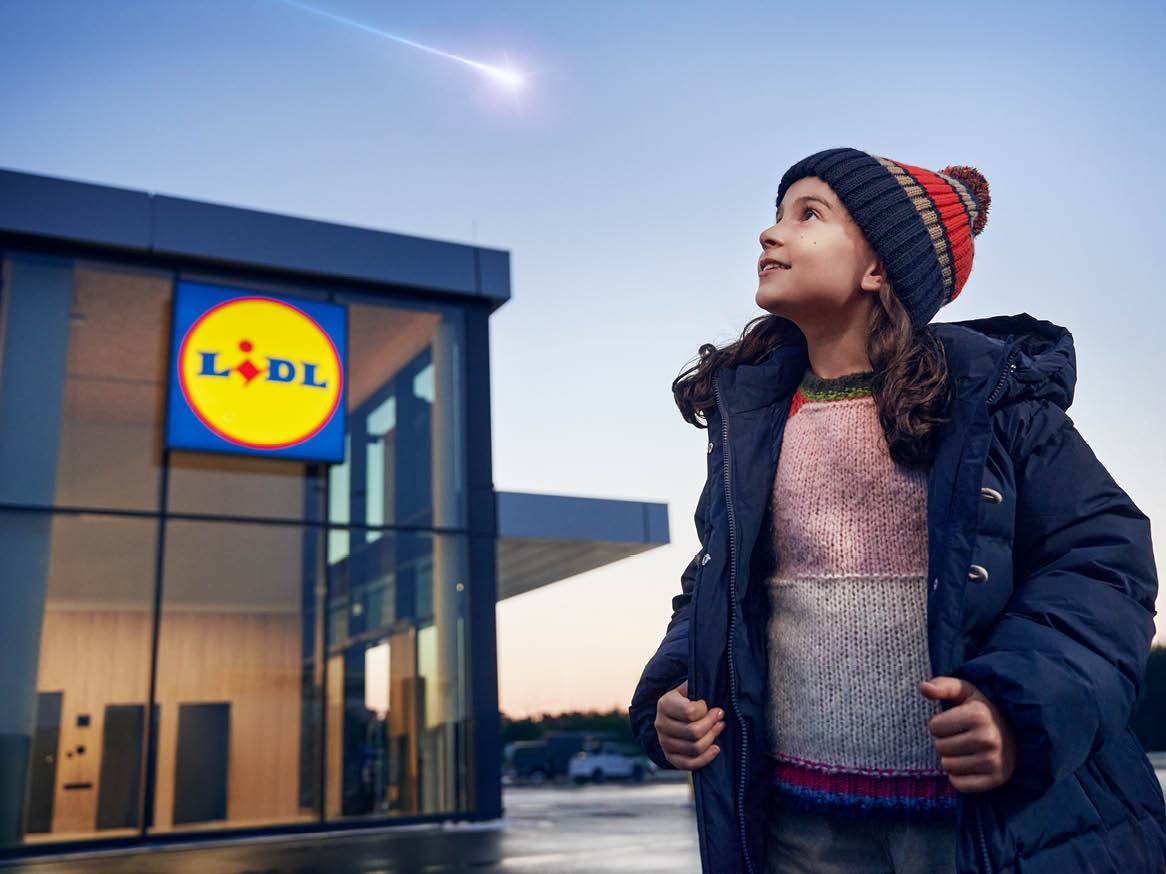 Момиче гледа падаща звезда пред магазин Lidl.