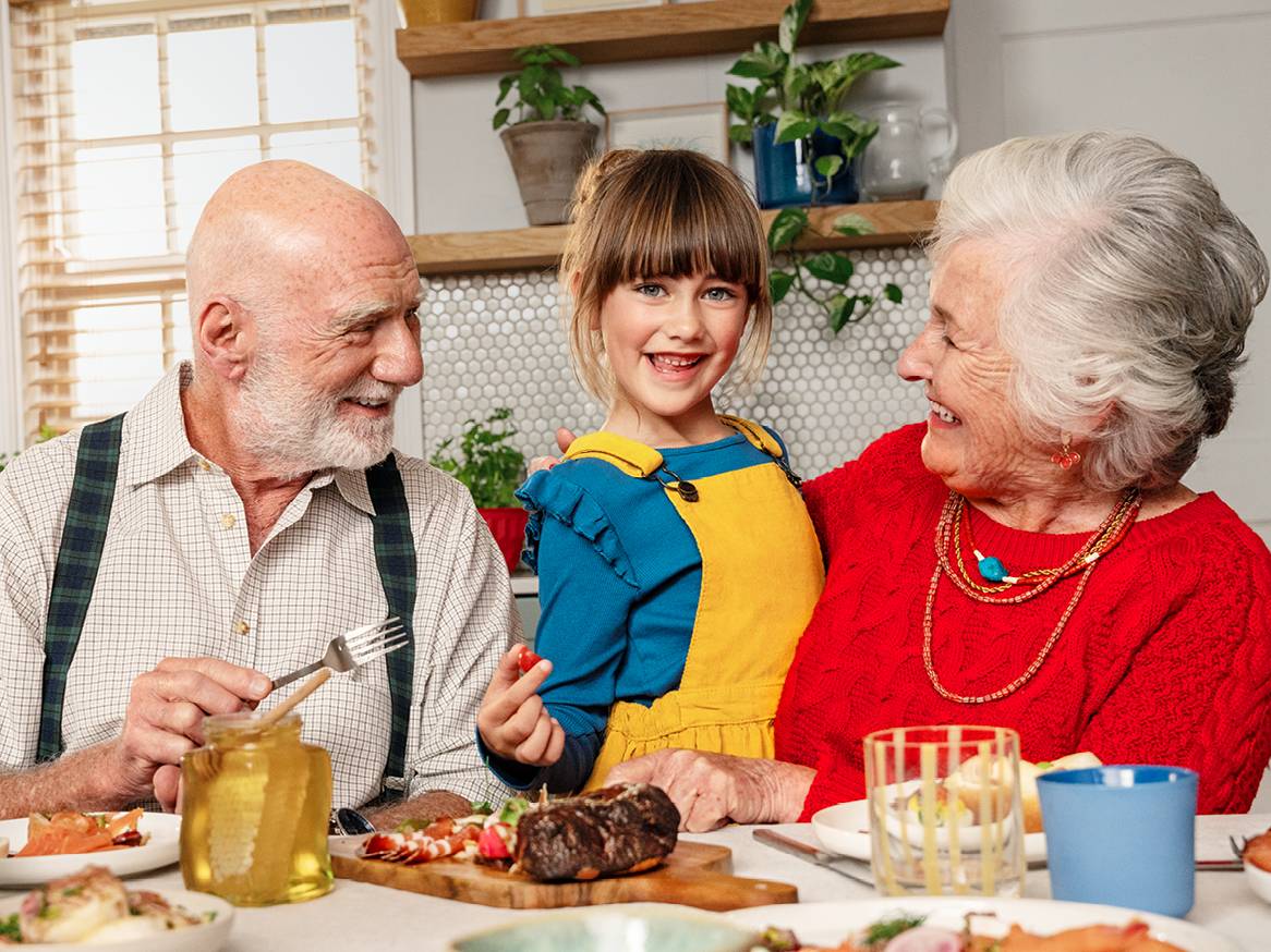 Семейство се наслаждава на празнична трапеза с месо, морски дарове и мед.