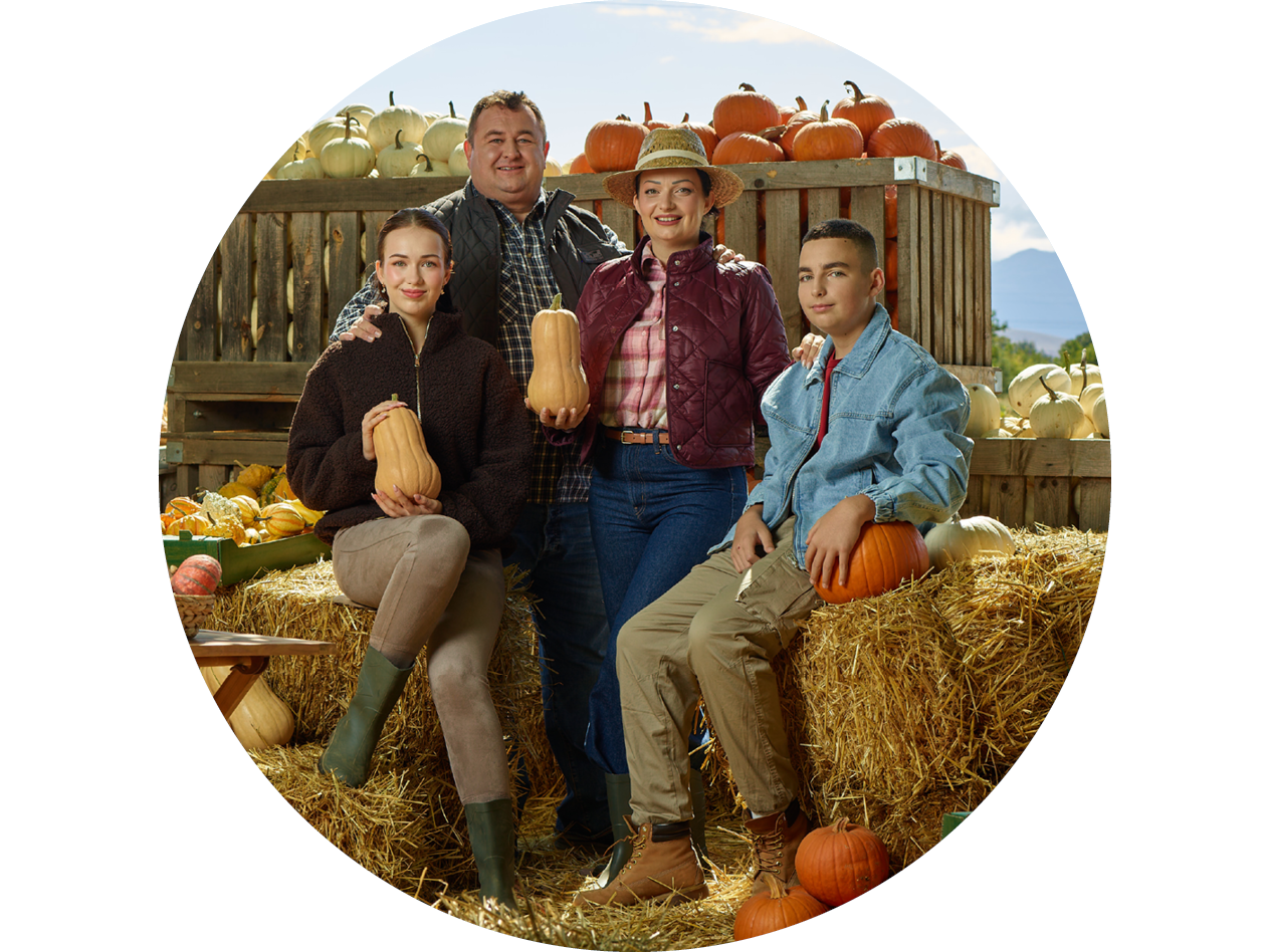 Семейство на тиквена ферма с тикви и бали сено