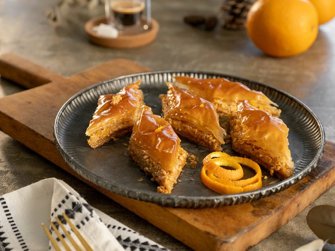 Баница с портокал на метална чиния.