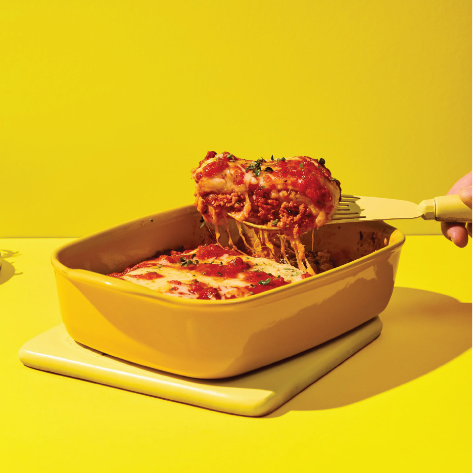 Лазаня със сирене и сос, сервирана в жълта тава за печене.