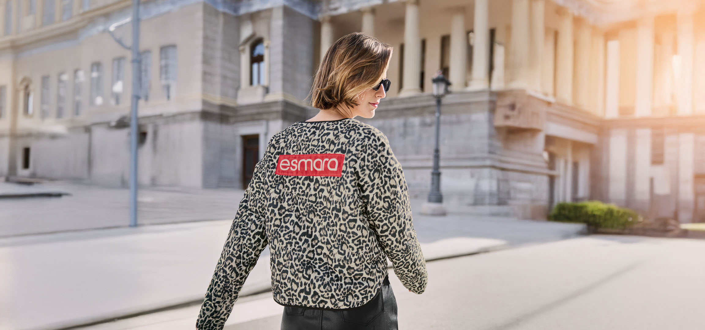 Жена с яке с леопардов принт Esmara, слънчеви очила, на градска улица.