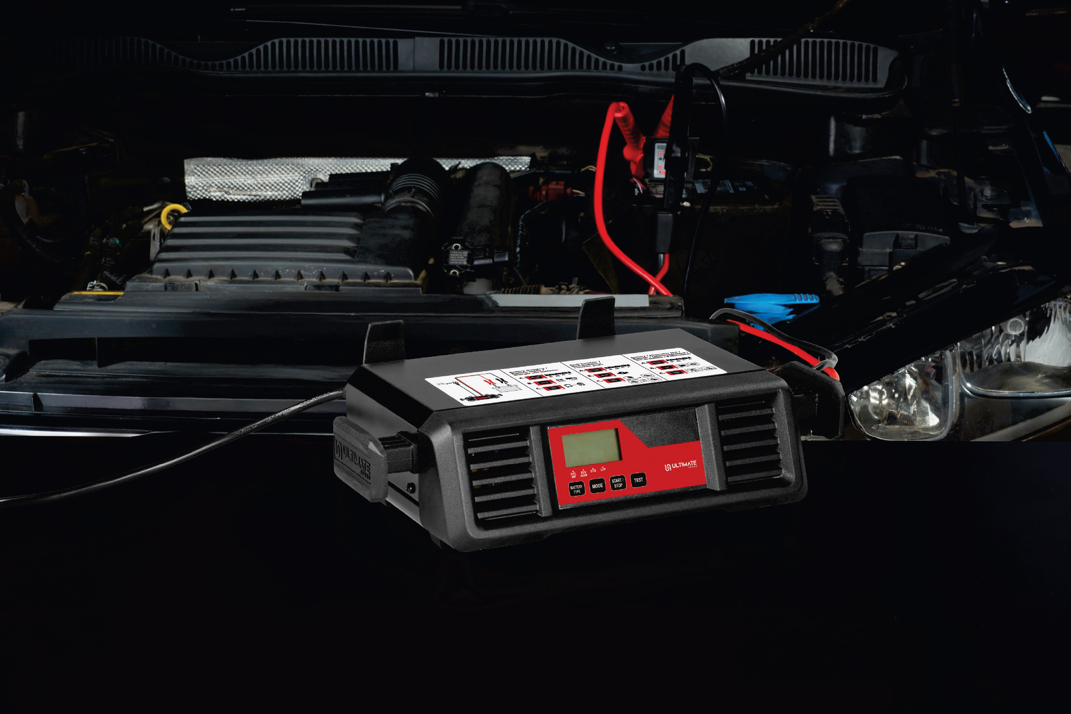 Зарядно устройство за акумулатор Ultimate Speed, свързано към двигател на автомобил.