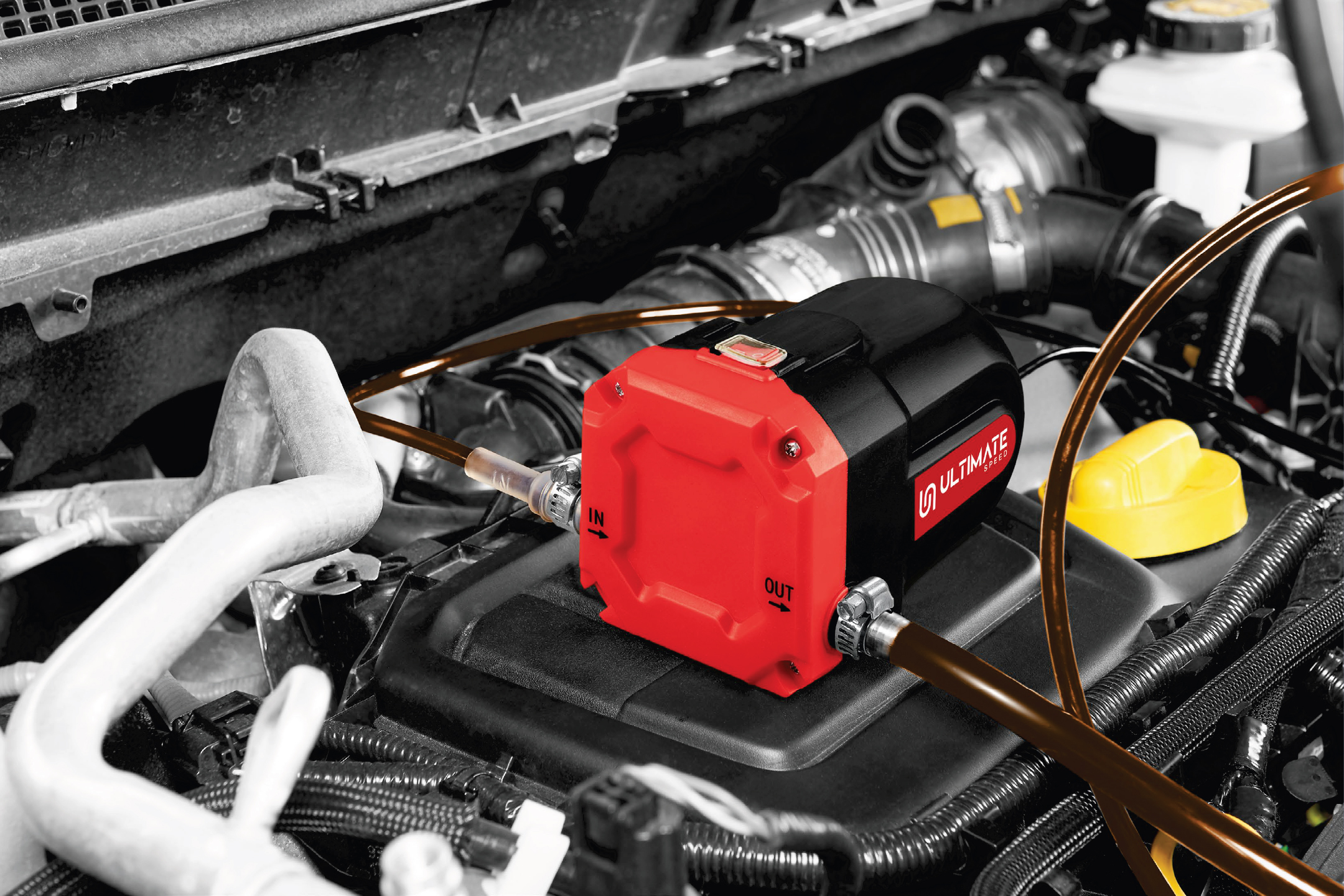 Червена и черна помпа за източване на масло в двигателния отсек на автомобил, с маркучи за входящ и изходящ поток.