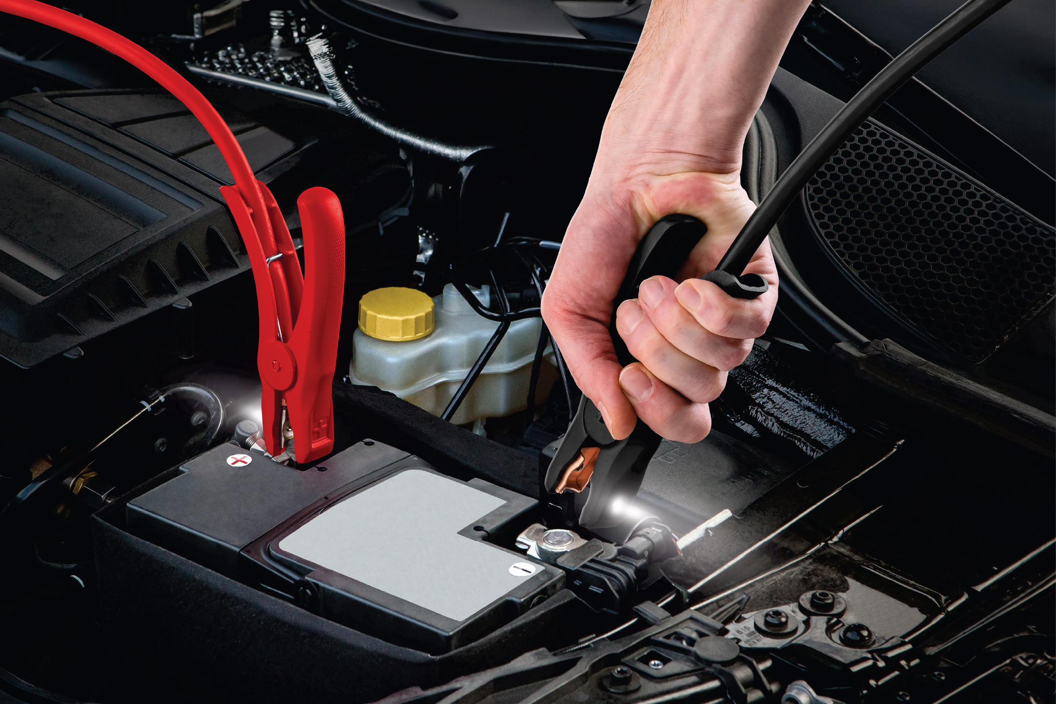 Мъж свързва кабели за подаване на ток към акумулатор на кола