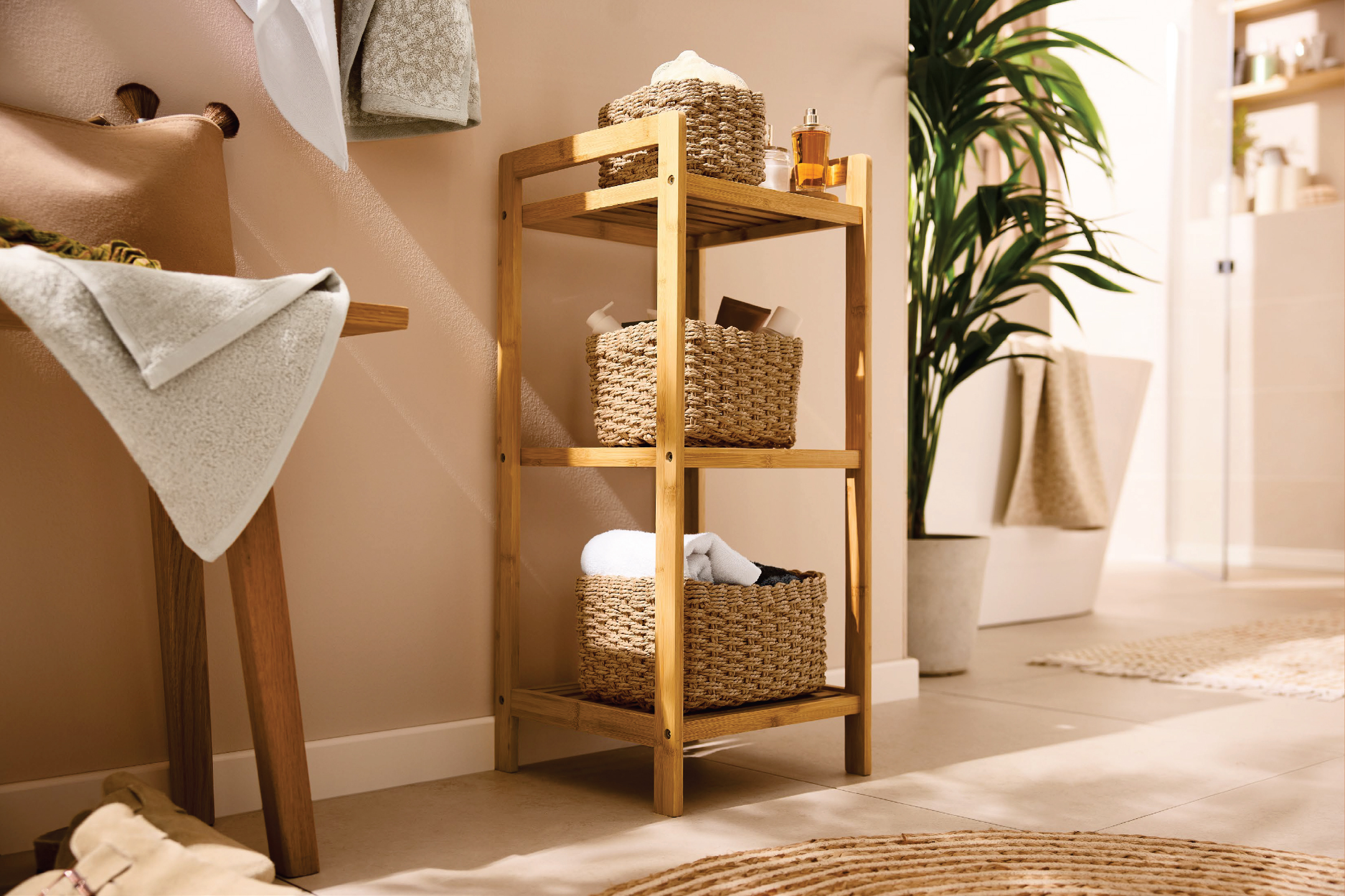 Дървена етажерка за баня с плетени кошници, кърпи и аксесоари за баня.