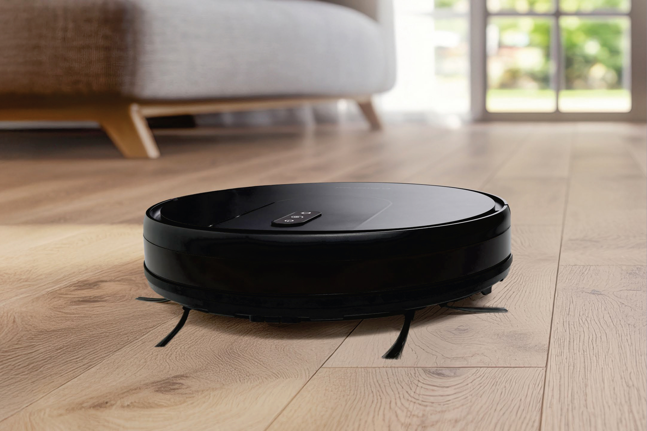 Черен робот прахосмукачка на дървен под пред диван и прозорец