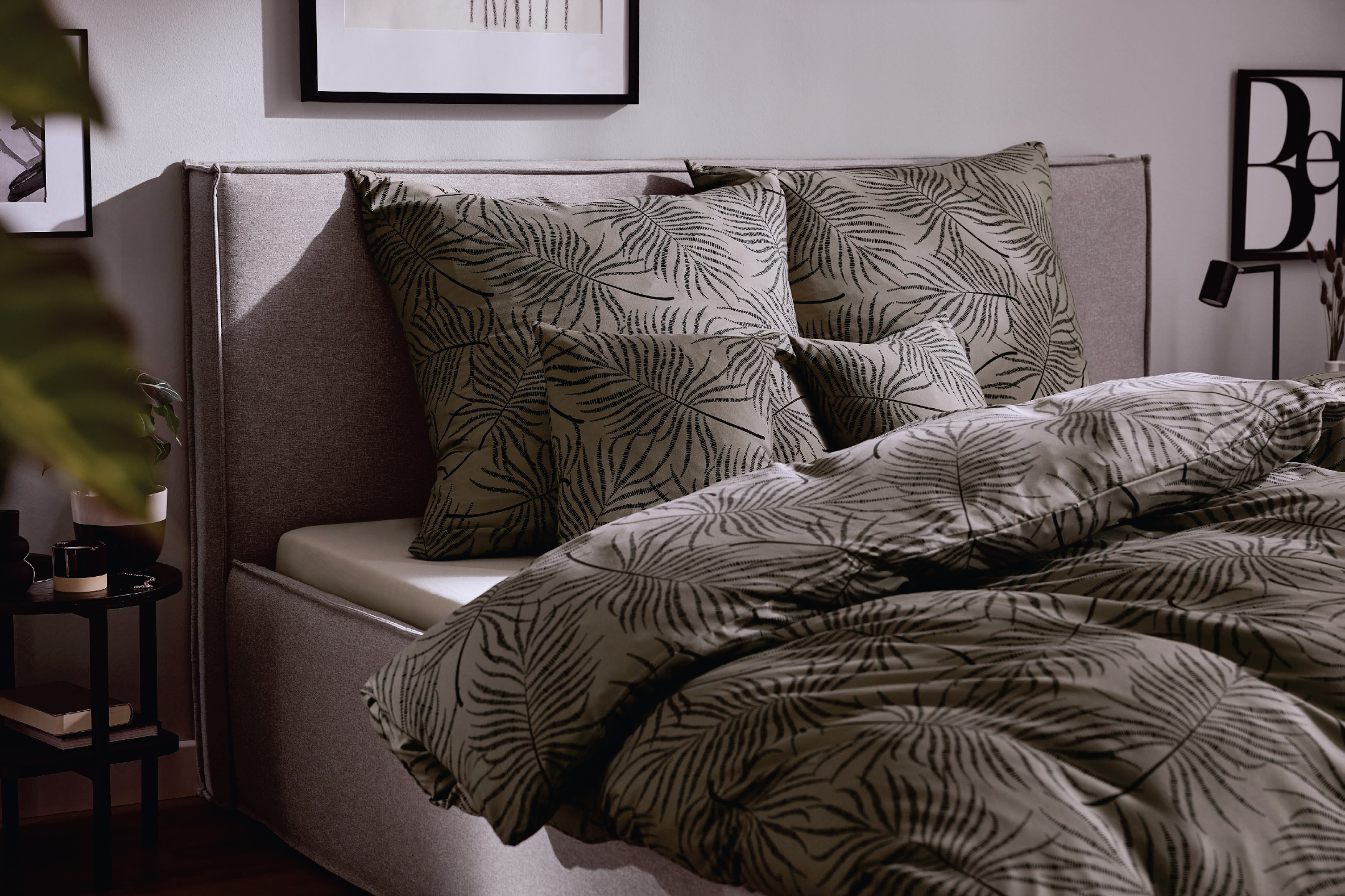 Спалня с тапицирана рамка и спално бельо с десен на палмови листа