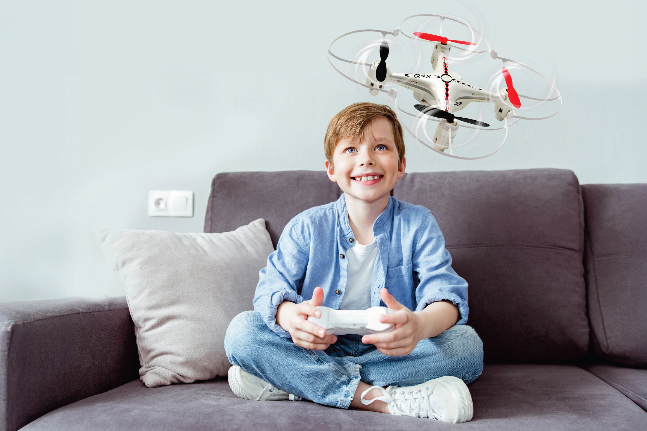 Момче играе с дрон на диван