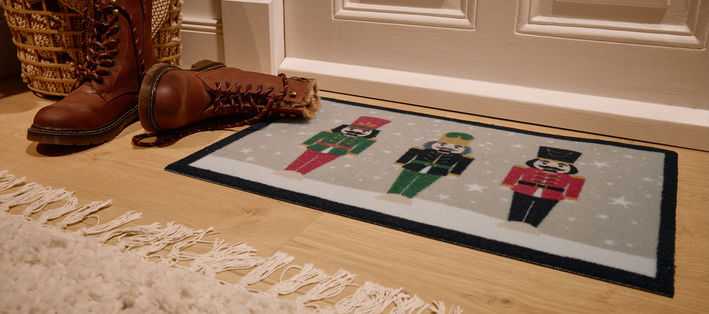 Коледна изтривалка с лешникотрошачки, кафяви ботуши и плетена кошница на входа.