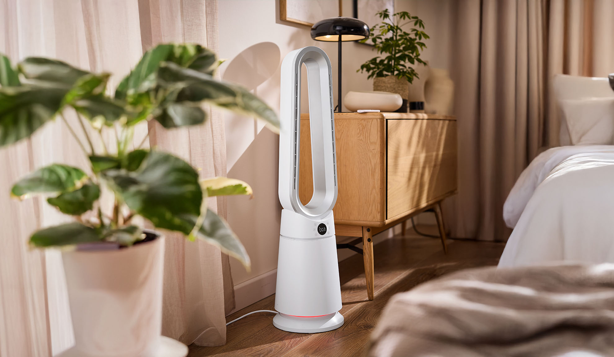 Бял вентилатор тип кула в модерна спалня с растения и дървени мебели.