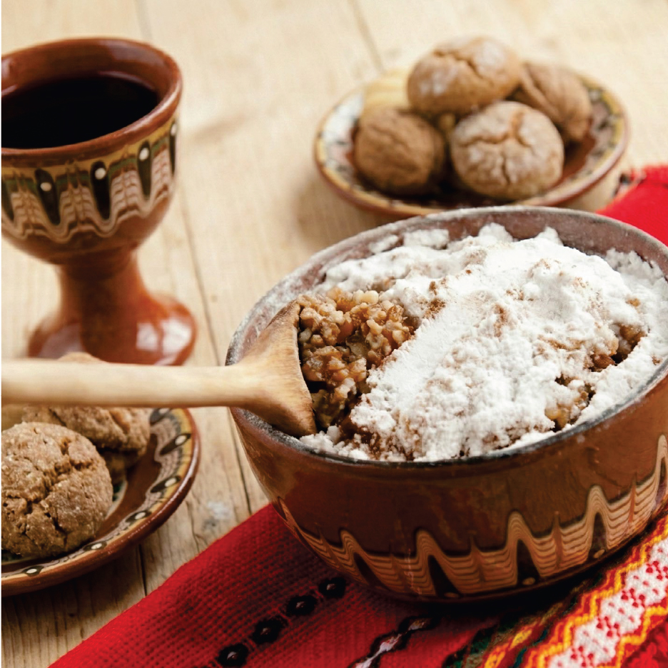 Кутия с варено жито, поръсено с пудра захар, дървена лъжица, вино и бисквити.